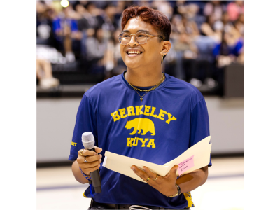 Elias smiling and holding a microphone