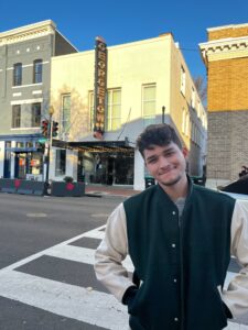 Christian smiling, standing next to a building sign labeled "Georgetown".